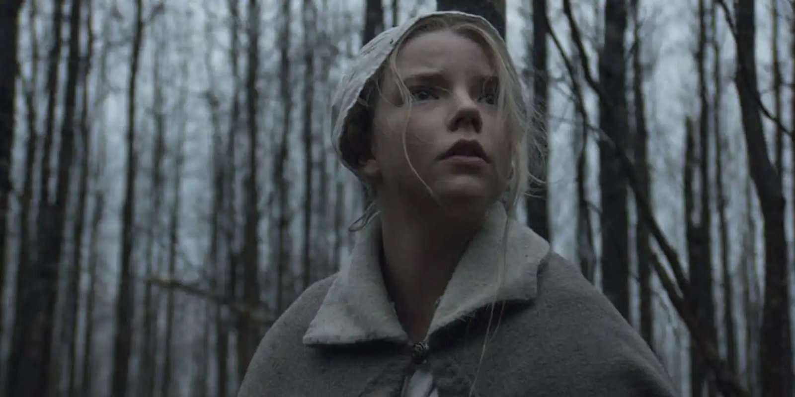 Anya Taylor-Joy as Thomasin looking scared in the woods in 'The Witch'.